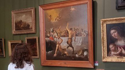 Une femme regarde le tableau "Le Festin des dieux" du peintre néerlandais Jan van Bijlert (1603-1671) exposé au musée Magnin de Dijon (Côte d'Or). (LOÏC VENNIN / AFP)