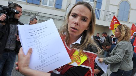 La d&eacute;l&eacute;gu&eacute;e FO Nadine Hourmant pr&eacute;sente une copie du jugement du tribunal de commerce de Quimper (Finist&egrave;re) annon&ccedil;ant la reprise de cinq des huit sites du p&ocirc;le frais de Doux, le 10 septembre 2012. (FRANK PERRY / AFP)