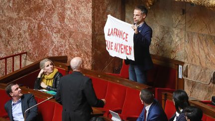 Le député Sébastien Nadot brandit une bannière à l'Assemblée nationale, le 19 février 2019. (JACQUES DEMARTHON / AFP)