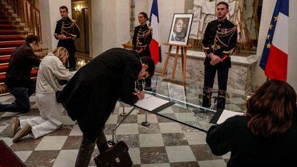 Des personnes signent les registres de condoléances en hommage à Jacques Chirac, à l'Elysée (Paris), le 26 septembre 2019. (GEOFFROY VAN DER HASSELT / AFP)