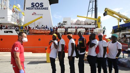 Des personnes débarquent de l'Aquarius à Trapani en Italie, le 16 septembre 2017. (TONY GENTILE / REUTERS)