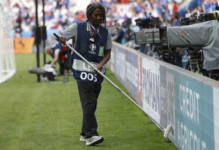 Un stadier&nbsp;tente de chasser les papillons de nuit qui ont envahi le Stade de France avant la finale de l'Euro, dimanche 10 juillet 2016. (Carl Recine / LIVEPIC / REUTERS)