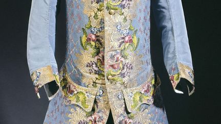 Gilet d’homme ayant appartenu à Claude-Lamoral II, Prince de Ligne et du Saint Empire, vers 1750. Gros de Tours liseré broché, soie bleue, fils de soie polychromes, fils d’argent doré ; boutons. en bois recouverts de filé et de paillons d’argent doré ; décor tissé à disposition. Collection Palais Galliera 
 (Collection Palais Galliera. © P. Ladet et C. Pignol / Galliera / Roger-Viollet)