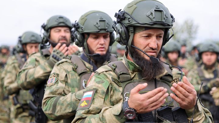 Des soldats tchétchènes en prière avant leur départ pour l'Ukraine, le 15 octobre 2022 dans la base militaire de Khankala, en Tchétchénie. (YELENA AFONINA / TASS / SIPA VIA AFP)