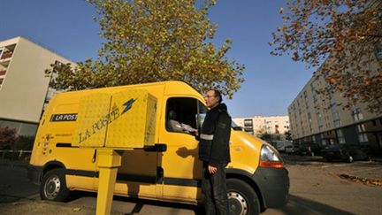 Un postier collectant du courrier dans une boîte aux lettres à Nantes (AFP - FRANK PERRY)