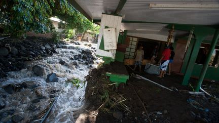 Des habitans observent les dégâts causés par des intempéries à Mahina, sur l'île de Tahiti (Polynésie Française), le 13 décembre 2015. (GREGORY BOISSY / AFP)