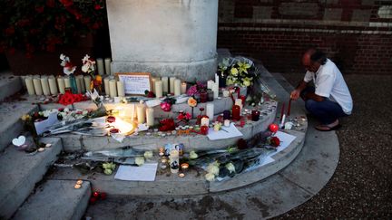 Des fleurs et des bougies disposées devant la mairie de Saint-Etienne-du-Rouvray (Seine-Maritime), le 26 juillet 2016. (CHARLY TRIBALLEAU / AFP)