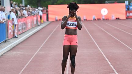 Shericka Jackson réagissant après sa blessure lors du 200 m au meeting de Gyulai Istvan Memorial, le 9 juillet 2024. (ATTILA KISBENEDEK / AFP)