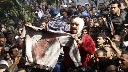 Un manifestant &eacute;gyptien brandit un v&ecirc;tement pr&eacute;sent&eacute; comme &eacute;tant celui d'une victime des violences polici&egrave;res, pr&egrave;s de la place Tahrir du Caire (Egypte), le 19 d&eacute;cembre 2011. (AP / SIPA)