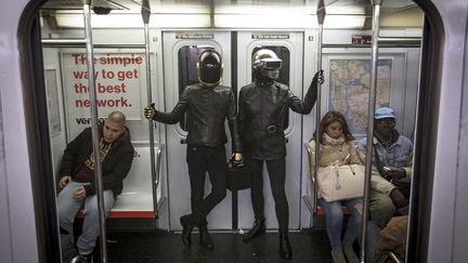 Qu'est-ce qui nous dit que ces deux hommes, photographiés&nbsp;samedi 31 octobre&nbsp;dans le métro new-yorkais, ne sont pas les vrais Daft Punk ?&nbsp; (CARLO ALLEGRI / REUTERS)