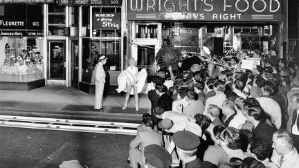 Marilyn Monroe et Tom Ewell, sur le tournage de la célèbre scène de la bouche d'aération dans&nbsp;7 ans de réflexion. La&nbsp;foule amassée autour du tournage nous rappelle l'adoration du public américain pour sa diva. (PHOTO BY SAM SHAW © SAM SHAW INC., COURTESY SHAW FAMILY ARCHIVES, LTD.)