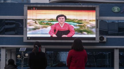 La présentatrice nord-coréenne Ri Chun Hee&nbsp;sur un écran géant à Pyongyang, le 11 janvier 2021. (KIM WON JIN / AFP)