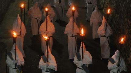 Des p&eacute;nitents portent des torchent pour la procession du Vendredi saint, tr&egrave;s t&ocirc;t vendredi 3 avril 2015, &agrave; Sorrento en Italie. (MARIO LAPORTA / AFP)