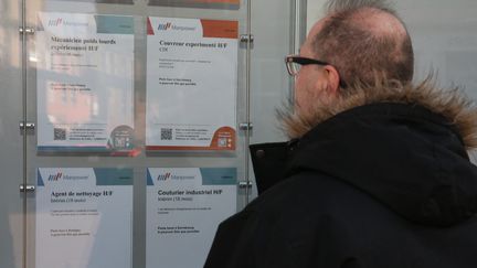 Un homme regarde les annonces d'une agence d'interim à Sarrebourg en Moselle, en mars 2024. (LAURENT MAMI / MAXPPP)