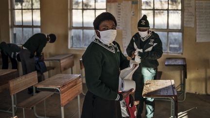 Une élève de l’école secondaire Sitoromo Junior à Sterkspruit, Afrique du Sud, prend du papier hygiénique pour nettoyer son bureau, le 6 juillet 2020. (MARCO LONGARI / AFP)