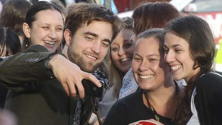 Robert Pattinson fait le malin avec des groupies en Australie. (ROB GRIFFITH / AP / SIPA)