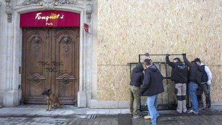 Des personnes mettent en place des protections sur les façades du Fouquet's.
 (RAFAEL YAGHOBZADEH/AP/SIPA / AP / SIPA)
