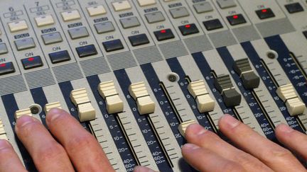 Un ingénieur du son travaille sur une table de mixage,  2004
 (MARTIN BUREAU / AFP)