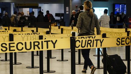 Une passag&egrave;re se dirige vers un portique de s&eacute;curit&eacute; de&nbsp;l'a&eacute;roport international de New York-John F. Kennedy (Etats-Unis), le 11 octobre 2014. (EDUARDO MUNOZ / REUTERS)