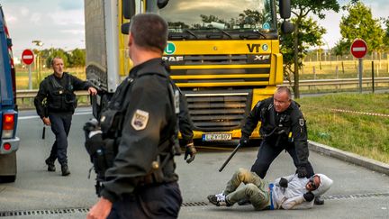 Beaucoup essaient de passer de l'autre c&ocirc;t&eacute; de la Manche mais pas sans heurts.&nbsp;Des gendarmes fran&ccedil;ais arr&ecirc;tent un migrant entr&eacute; dans l'Eurotunnel &agrave; Coquelles pr&egrave;s de Calais le 30 juin 2015. Le jour m&ecirc;me, les autorit&eacute;s ont affirm&eacute; que dix migrants ont perdu la vie le mois pr&eacute;c&eacute;dent en tentant de passer en Angleterre. (PHILIPPE HUGUEN / AFP)