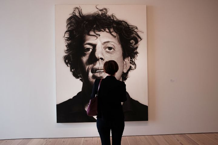 Une femme observe "Phil" tableau réalisé par Chuck Close en 1969, qui représente son ami, le compositeur&nbsp;Philip Glass. Exposition au&nbsp;Whitney Museum of American Art&nbsp;à New York, le 23 avril 2015 (SPENCER PLATT / GETTY IMAGES NORTH AMERICA)