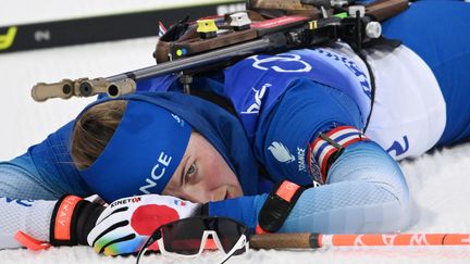 La biathlète française Justine Braisaz-Bouchet à terre, le 11 février 2022, durant le relais féminin aux Jeux olympiques de Pékin.&nbsp; (MILLEREAU PHILIPPE / KMSP / AFP)