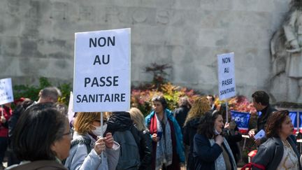 Des pancartes opposées à la création du pass sanitaire lors d'une manifestation à l'appel de l'association Ami entends-tu, à Paris, le 22 mai 2021. (JEROME LEBLOIS / HANS LUCAS / AFP)