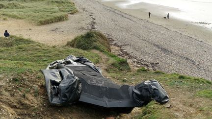 the remains of an inflatable boat in the dunes of Wimereux (Pas-de-Calais), November 28, 2021. (JAAK MOINEAU / HANS LUCAS / AFP)