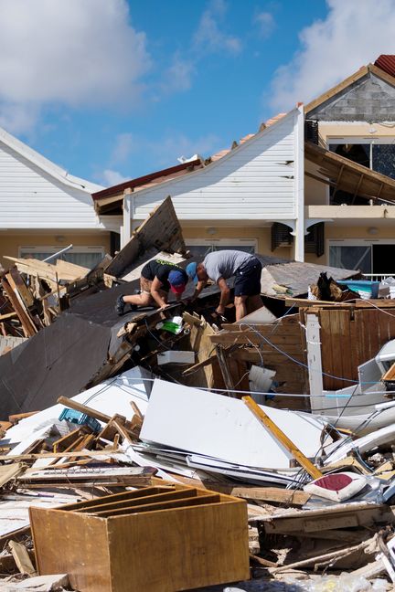 Deux hommes fouillent les ruines&nbsp;d'un restaurant de la Baie-Orientale, le 10 septembre 2017, après le passage de l'ouragan Irma sur l'île de Saint-Martin. (MARTIN BUREAU / AFP)