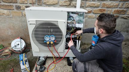 Un technicien installe une pompe à chaleur dans le Morbihan, en janvier 2021. (FRANCOIS DESTOC / MAXPPP)