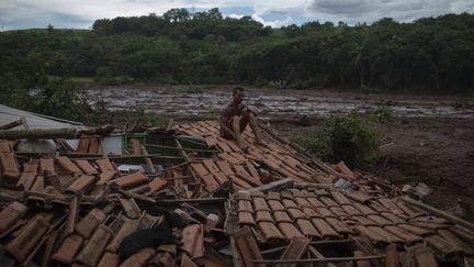 "Tout tremblait et j'ai vu d'énormes arbres et des personnes disparaître sous la boue", a déclaré Emerson dos Santos, 30 ans, assis sur le toit de la maison de sa famille emportée par l'effondrement d'un barrage minier&nbsp;près&nbsp;de Brumadinho, dans l'État de Minas Gerais, dans le sud-est du Brésil, le 26 janvier 2019. (MAURO PIMENTEL / AFP)