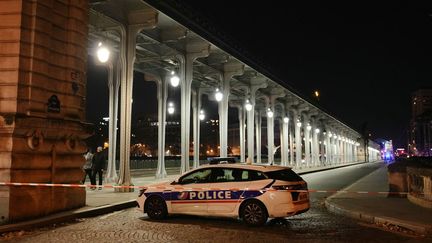 Une voiture de police garée devant le pont de Bir-Hakeim, après qu'une personne a été tuée et deux autres blessées lors d'une attaque au couteau à Paris, le 2 décembre 2023. (DIMITAR DILKOFF / AFP)