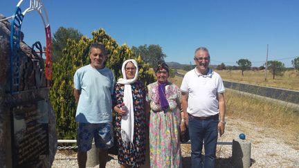 Deux fils de harkis et leurs mères devant la stèle rendant hommage aux forces "supplétives et assimilées", en face du camp Joffre près de&nbsp;Rivesaltes (Pyrénées-Orientales). (RADIO FRANCE / STÉPHANE IGLÉSIS)