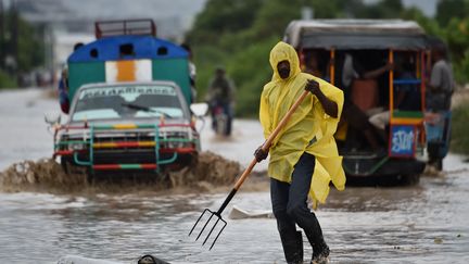 Un homme nettoie les ordures emportés par l'ouragan dans les rues de Port-au-prince (Haïti), le 4 octobre 2016. (HECTOR RETAMAL / AFP)