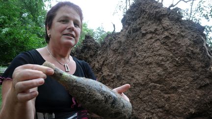 L'une des descendantes Ottenwaedler tient une des bouteilles enfouies par son arri&egrave;re-grand-p&egrave;re durant la Seconde Guerre mondiale, le 2 juillet 2012 &agrave; Ch&acirc;tenois (Bas-Rhin). (FRANCK DELHOMME / MAXPPP)