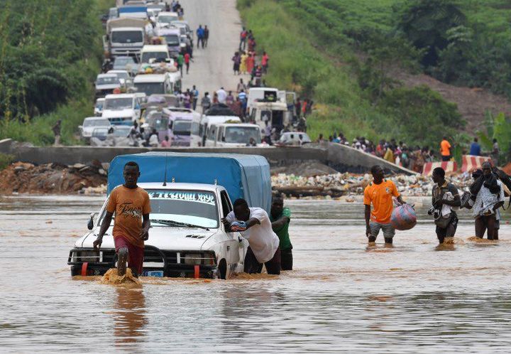 Traversée d'une rivière après des pluies torrentielles à Abidjan en mai 2017 (ISSOUF SANOGO / AFP)