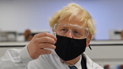 Le Premier ministre britannique Boris Johnson pose avec un flacon du vaccin d'AstraZeneca&nbsp;contre le Covid-19, au Pays de Galles le 30 novembre 2020. (PAUL ELLIS / POOL / AFP)