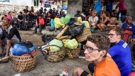 Des randonneurs et leurs guides bloqués sur le mont Rinjani,&nbsp;le 29 juillet 2018, dans un village de l'île de Lombok (Indonésie). (ANTARA FOTO AGENCY / REUTERS)