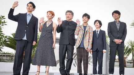 Les acteurs et actrices du film Monster, de Hirozaku Kore-Eda, entourent le réalisateur au sommet des marches du Festival de Cannes 2023. (FRED DUGIT / MAXPPP)