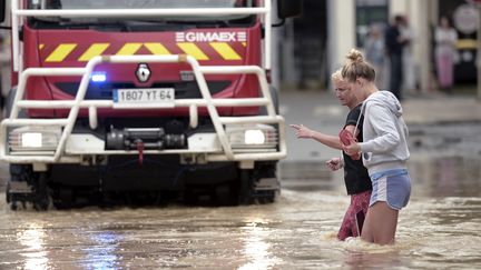 Deux femmes traversent une rue inondée de&nbsp;Salies-de-Béarn (Pyrénées-Atlantiques), le 13 juin 2018. (IROZ GAIZKA / AFP)