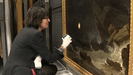 Sophie Lessard, directrice du musée des Beaux-Arts de Brest, "ausculte" un tableau à la recherche d'éventuels champignons  
 (Capture d&#039;image France 3/Culturebox)