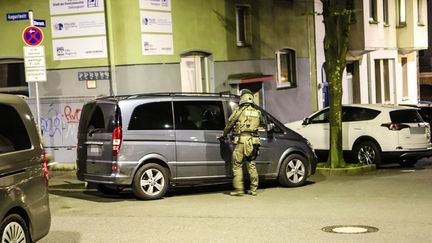 Un officier de police se tient près d'une camionnette lors d'une opération anti-mafia menée dans plusieurs États allemands, le 3 mai 2023 à Hagen, en Rhénanie-du-Nord-Westphalie. (ALEX TALASH / DPA / AFP)