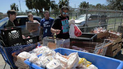 Des bénévoles distribuent de la nourriture aux familles sinistrées de l'ouragan Ian à Fort Myers (Floride), le vendredi 30 septembre.&nbsp; (JOSEPH AGCAOILI / AFP)