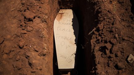 Le cercueil d'une femme noire non identifiée, ainsi qu'il est écrit sur le couvercle, sur le point d'être mis en terre dans le cimetière d'Olifantsvlei, près de Johannesburg, le 27 février 2019. (GUILLEM SARTORIO / AFP)