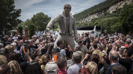 Des fans de Johnny Hallyday réunis autour d'une statue du chanteur, à Viviers (Ardèche), le 16 juin 2018. (JEAN-PHILIPPE KSIAZEK / AFP)