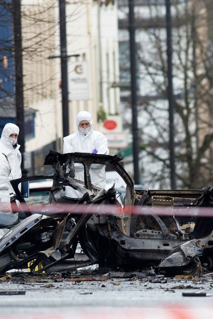 La police scientifique inspecte la carcasse de la voiture piégée qui a explosé devant le tribunal de Derry-Londonderry, le 20 janvier 2019. (PAUL FAITH / AFP)