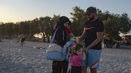 Une famille de réfugiés syriens sur la plage de Menekse, à Istanbul, le 28 juillet 2019. (YASIN AKGUL / AFP)