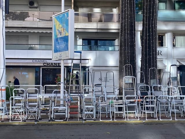 Escabeaux, sièges et chaises pliantes posés sur le trottoir en face de la montée des marches par les photographes amateurs à Cannes, le 14 mai 2023. (Mohamed Berkani)