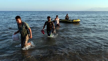 Un groupe de migrants originaires de Birmanie d&eacute;barquent sur les c&ocirc;tes de l'&icirc;le grecque de Kos, le 18 ao&ucirc;t 2015. (LOUISA GOULIAMAKI / AFP)