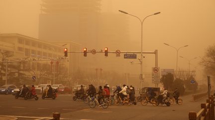 Des usagers de la route dans la tempête de sable et la pollution à Pékin, le 15 mars 2021. (KOKI KATAOKA / YOMIURI / AFP)